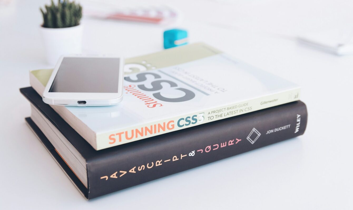 white smartphone on two softbound books
