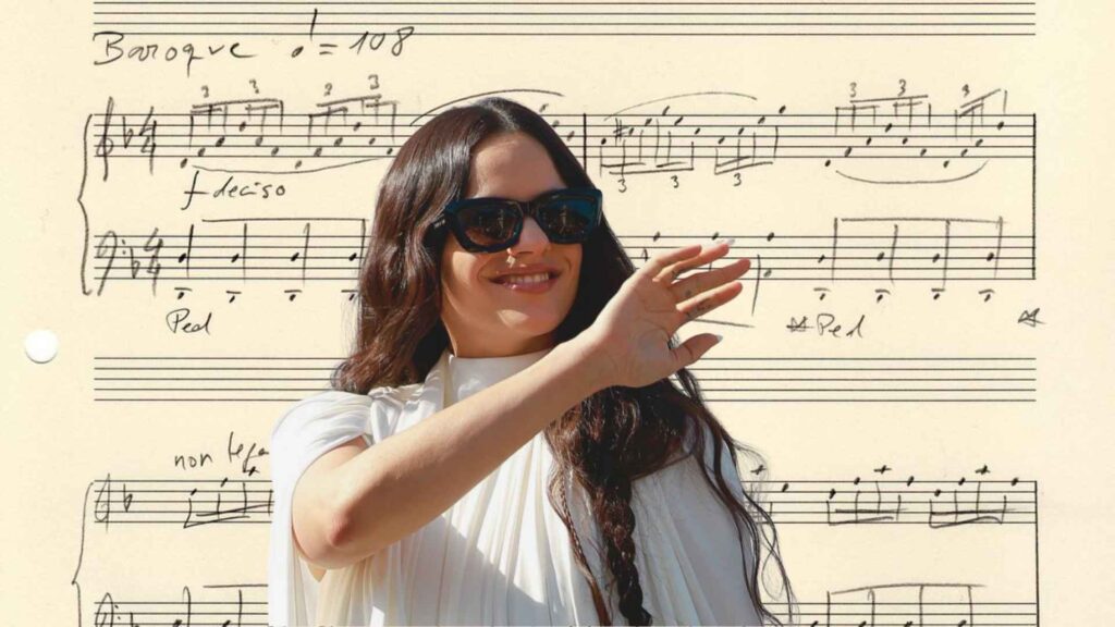 Rosalía sonríe vestida de blanco frente a una imagen de la partitura manuscrita de Berghain como fondo.