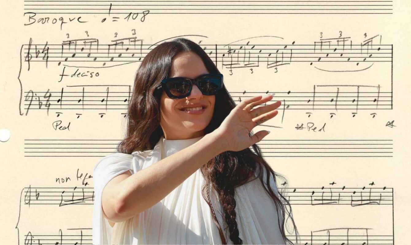 Rosalía sonríe vestida de blanco frente a una imagen de la partitura manuscrita de Berghain como fondo.