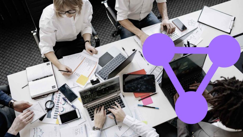 Equipo de trabajo analizando gráficos y datos en mesa con ordenadores, representación del sistema de medición del Observatorio