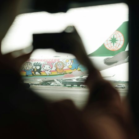 Someone is photographing a colorful airplane.