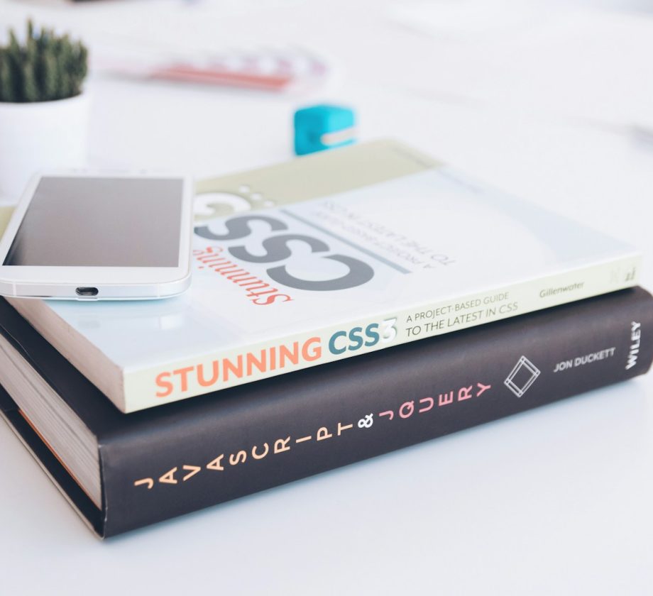 white smartphone on two softbound books